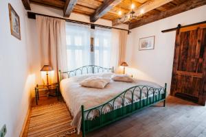 a bedroom with a bed and a large window at Cabana Huta Slavia in Şinteu