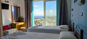a hotel room with two beds and a large window at Planet View in Faliraki +291 photos