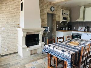 a kitchen with a dining table with a fireplace at Gîte "Chez Paulette" Proche Zoo de Beauval in Mareuil-sur-Cher