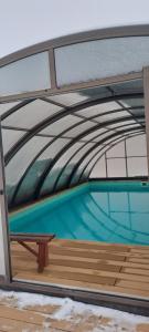 a bench sitting on a deck with a swimming pool at Apartman FARMA HRADEC in Mnichovo Hradiště