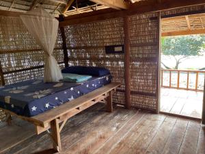a bed in a room in a straw hut at Naks Shack in Koh Ta Kiev