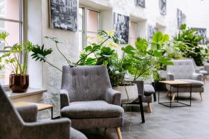 a row of chairs and tables with plants in a room at Hestia Hotel Ilmarine in Tallinn