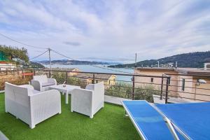 a balcony with white chairs and a table and a view at Infinity Blue in Portovenere