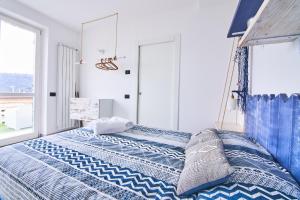 a bedroom with a blue and white bed with a window at Infinity Blue in Portovenere +21 photos