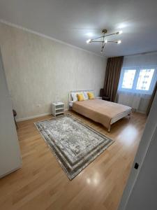 a large bedroom with a bed and a rug at RentHouse Samal in Astana