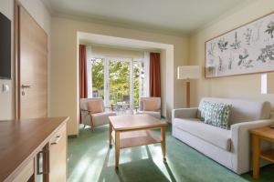 a living room with a couch and a table at IFA Graal-Müritz Hotel & Spa in Graal-Müritz