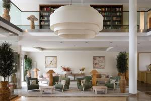 a lobby with chairs and tables and a large chandelier at IFA Graal-Müritz Hotel & Spa in Graal-Müritz