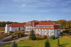 a large building with a red roof on a street at IFA Graal-Müritz Hotel & Spa in Graal-Müritz