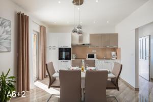 a kitchen and dining room with a table and chairs at Apartmani Dalibor, Stanići - Omiš in Stanići