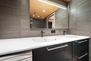 a bathroom with two sinks and a mirror at Fyri Tunet Hemsedal in Hemsedal +39 photos