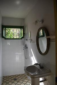 uma casa de banho com um lavatório, um espelho e uma janela em Cortijo Don Rodrigo em El Chorro
