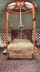 a canopy bed with a wooden frame in a tent at Arkeo - Luxury tents and cabins at the river in Nonceveux