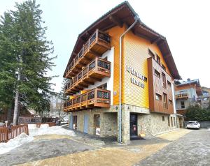 a yellow building with balconies on the side of it at Holiday Family Raj pod Sosnami centrum miasta! in Szklarska Poręba