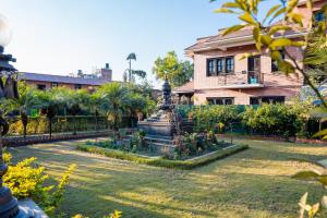 a house with a fountain in front of a yard at Hotel Yechu Comfort Heritage in Bhaktapur