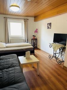 ein Zimmer mit einem Bett, einer Couch und einem Tisch in der Unterkunft Hotel Jungbräu in Abensberg