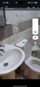a bathroom with a white toilet and a sink at Jawhara zarka in Saïdia