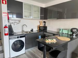 a kitchen with a sink and a washing machine at Seaview Suite in Caniço