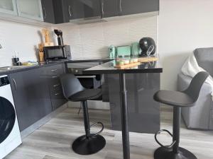 a kitchen with a table and two bar stools at Seaview Suite in Caniço