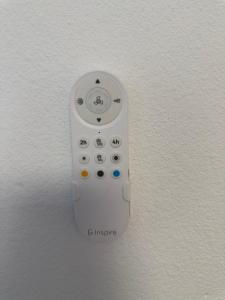 a white remote control hanging on a wall at Seaview Suite in Caniço +2 photos