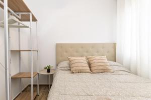 a bedroom with a bed with a white wall at Cielito Lindo Tu hogar temporal con encanto in Torrent +26 photos