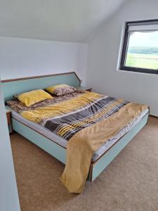 a large bed in a room with a window at Amore Resort in Băltenii de Sus