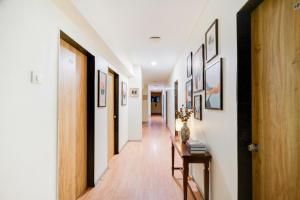 a hallway with white walls and wooden floors at FabHotel White Ridge Chaitanyapuri in Hyderabad