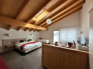 a bedroom with a bed and a desk and a television at Chalet Gafri -Boutique B&B - comfort and hospitality - near Interlaken in Wilderswil