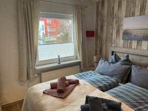 a teddy bear sitting on a bed in a bedroom at Apartment Alleestraße in Büsum