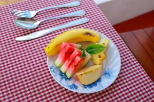 a plate with a banana and fruit on a table at Cloud 9 Cottages Ella in Ella +32 photos