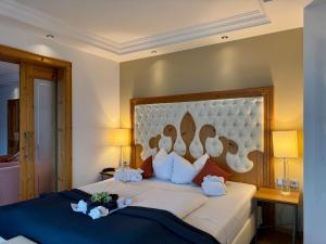 a bedroom with a large bed with a large headboard at Wellness Hotel Bayerischer Hof in Rimbach +28 photos