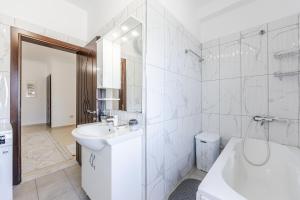 a white bathroom with a sink and a tub at Castle Serenity Home 3BR with Free Parking by PikHost in Gjirokastër +37 photos