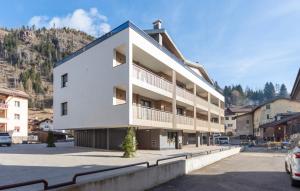 a white building with a blue roof at Vacanze la Malga in Predazzo
