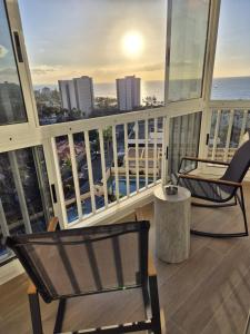 a balcony with two chairs and a view of the ocean at Vibre Canaris - Las Americas in Playa de las Americas