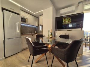 a kitchen with a table and chairs and a refrigerator at Vibre Canaris - Las Americas in Playa de las Americas
