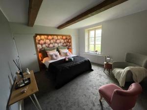 a bedroom with a bed and a couch and a chair at Maison Longue de La Cassine in Vendresse