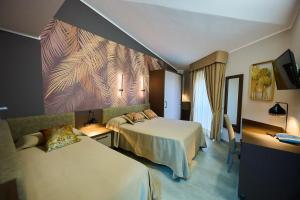 a hotel room with two beds and a painting on the wall at Le 2 Palme Apartments in Catanzaro Lido
