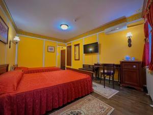 a bedroom with a bed and a desk and a table at Family Hotel at Renaissance Square in Plovdiv