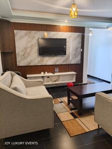 a living room with a tv and a couch and a table at The Africana Hotel in Isiolo