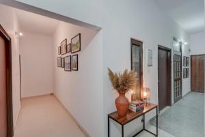 a hallway with a table with a vase on it at FabHotel Tree view Residency in Lucknow