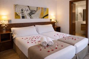 a hotel room with a bed with red roses on it at Aston Hotel in Andorra la Vella