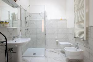 a white bathroom with a sink and a toilet at R&B Giardino 34 in Forlì +40 photos
