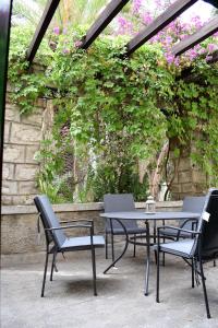 een patio met een tafel, stoelen en bloemen bij Cortijo Don Rodrigo in El Chorro