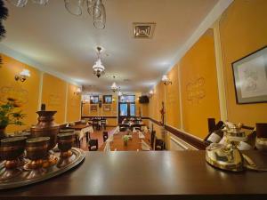 a room with yellow walls and a table and chairs at Family Hotel at Renaissance Square in Plovdiv