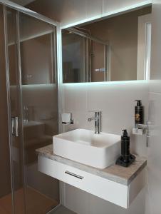 a bathroom with a white sink and a mirror at Rafina Studio apartments kondilia in Rafina +70 photos