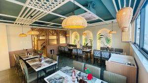 a dining room with tables and chairs and chandeliers at Elegance Inn in Varanasi