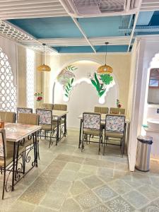 a dining room with tables and chairs and a painting on the wall at Elegance Inn in Varanasi
