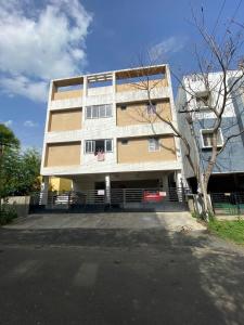 a tall building with a car parked in front of it at Kundrathur home stay - Krishna's Casa S1 in Tirurāgeswaram