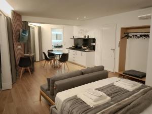 a living room with a couch and a kitchen with a table at Rafina Studio apartments kondilia in Rafina