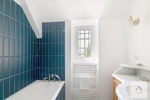 a bathroom with a tub and green tiles at La Villa Moorings in Saint Malo +43 photos