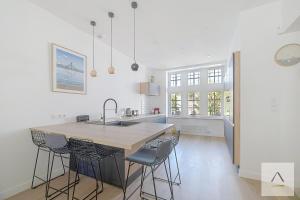 a kitchen with a large island with bar stools at La Villa Moorings in Saint Malo